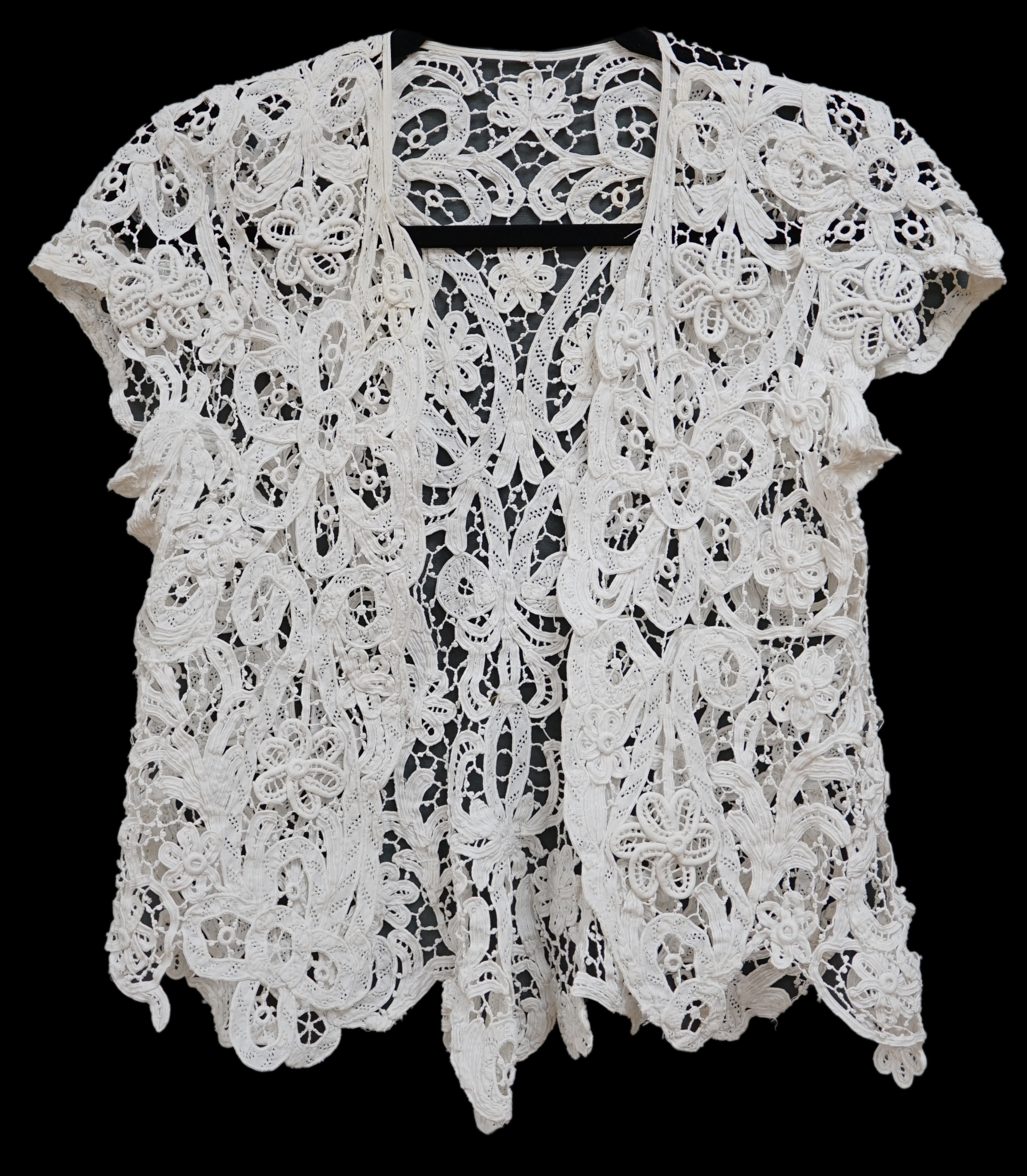 An Edwardian ladies white lace bolero, a tape lace Edwardian cap sleeve bolero with hand sewn bracts, attaching the tape lace together, possibly part of a wedding dress or summer dress, back under arm width 36cm. Conditi